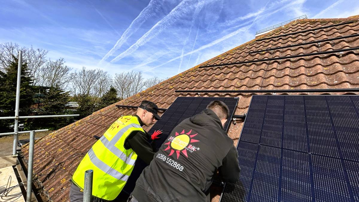 Installers fitting solar panels to a roof