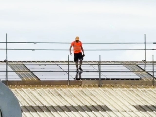 Solar panel installer walking on panels.